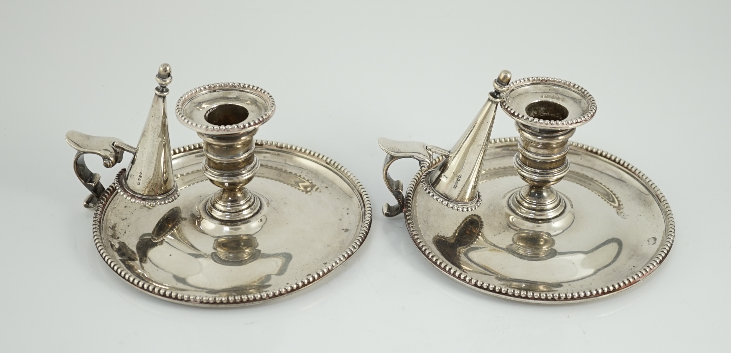 A pair of Victorian silver chambersticks and extinguishers, by Charles Thomas Fox and George Fox